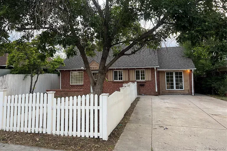 small red home with white picket fence