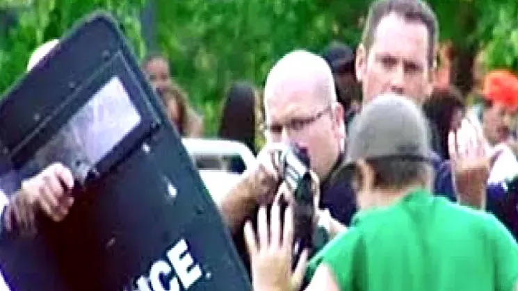 Attorney David Lane sees this CBS4 photo of an Aurora police officer pointing a rifle at an innocent teen bystander as exemplifying the post-robbery incident. - CBS4