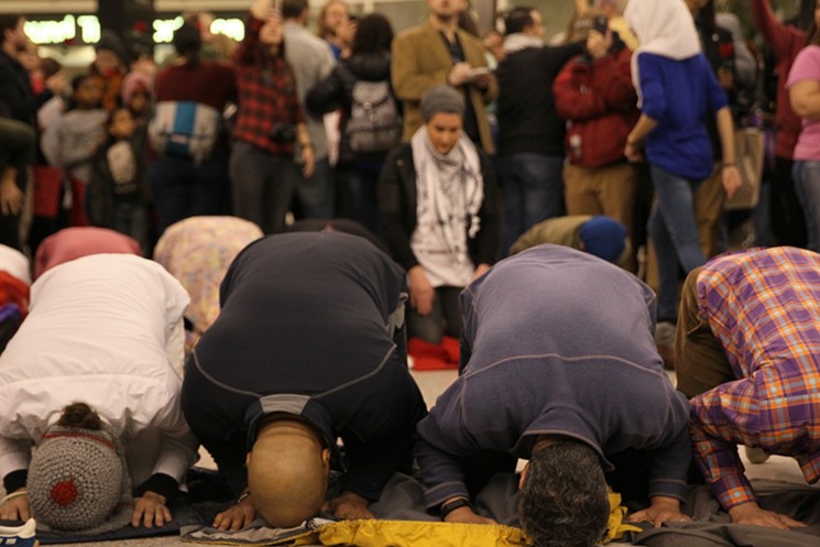 Muslim protestors pray in DIA's Great Hall. - BRANDON MARSHALL