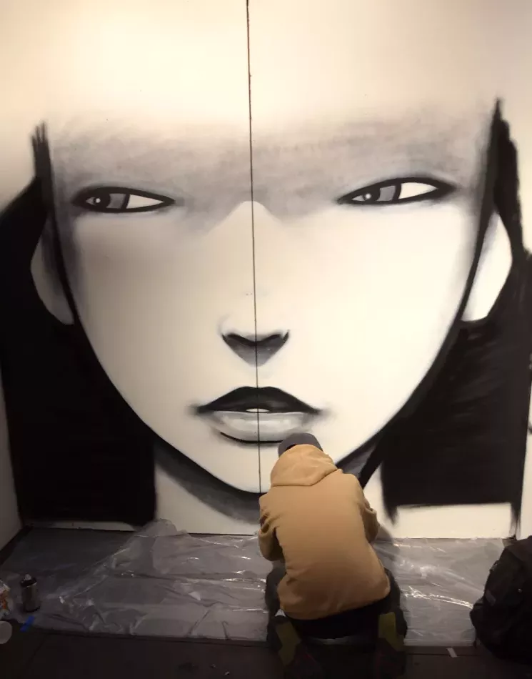 Casey Kawaguchi paints a mural at Artopia 2017. - LINDSEY BARTLETT