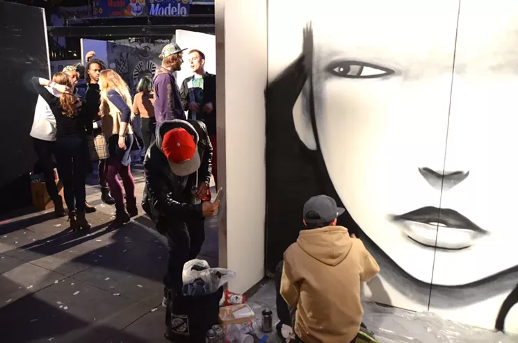 Casey Kawaguchi paints a mural at Artopia 2017. - LINDSEY BARTLETT