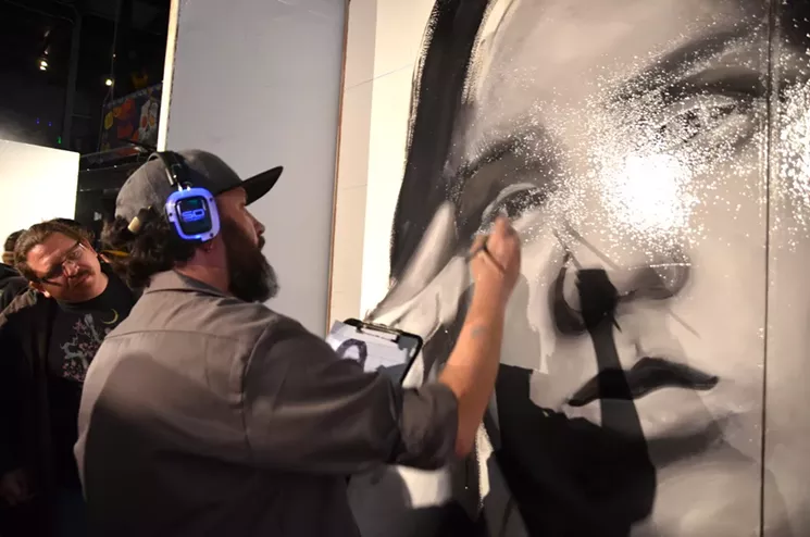 Patrick McGregor paints a mural at Artopia 2017. - LINDSEY BARTLETT