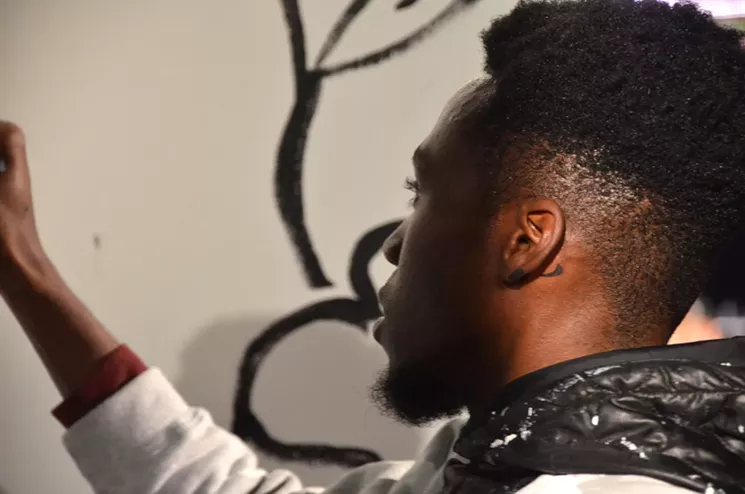 Lionel-Bravo Bumbakini paints at Artopia 2017. - LINDSEY BARTLETT