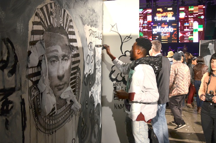 Lionel-Bravo Bumbakini paints at Artopia 2017. The mural was also in collaboration with Jeromie Dorrance and Christian Salgado, both Dateline Gallery artists. - LINDSEY BARTLETT