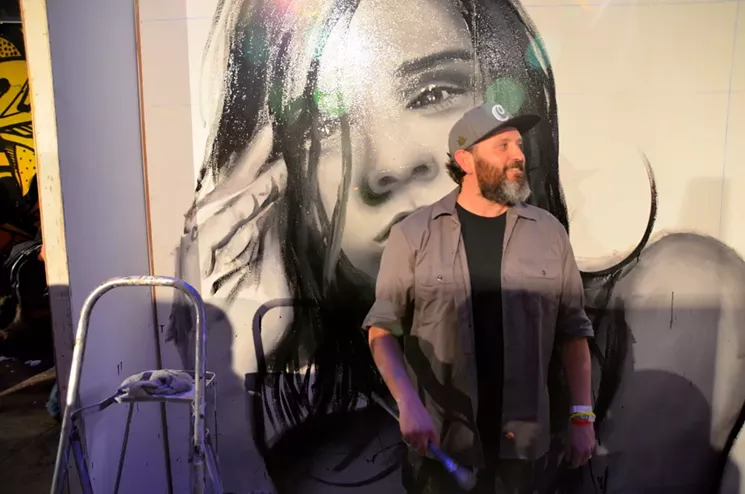 Patrick McGregor paints a mural at Artopia 2017. - LINDSEY BARTLETT