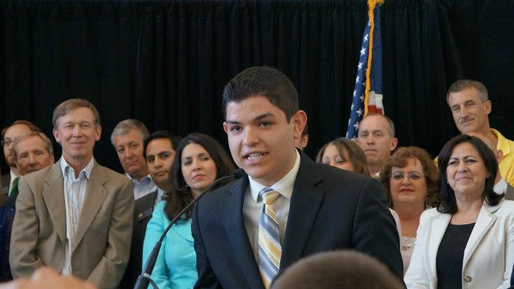 Marco Dorado speaking in 2013 at the signing of the ASSET bill, which granted in-state tution rates to all Colorado high-school graduates regardless of their immigration status. His audience includes Governor John Hickenlooper, legislators Crisanta Duran and Angela Giron and former Denver Nuggets great turned broadcaster Bill Hanzlik. - COURTESY OF MARCO DORADO