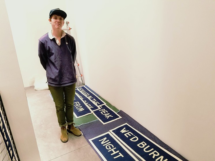 Artist Jackie Barry installing her stairwell piece. - LINNEA COVINGTON