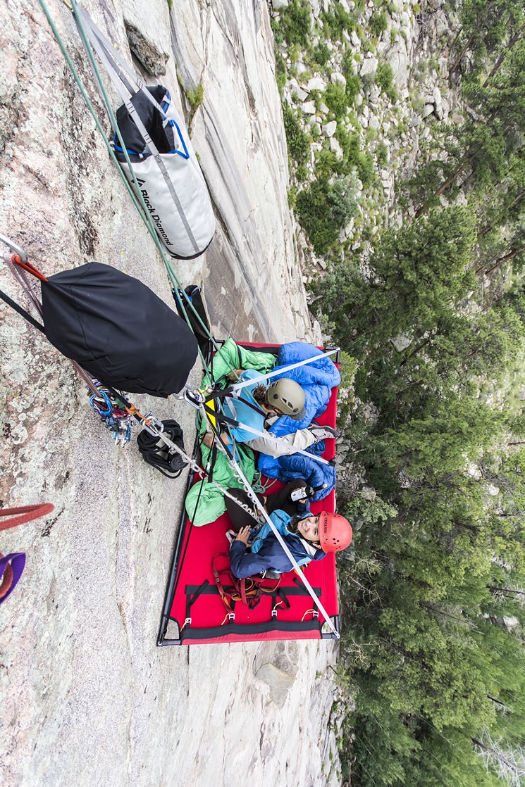 Two people suspended on a portaledge. - COURTESY REED ROWLEY