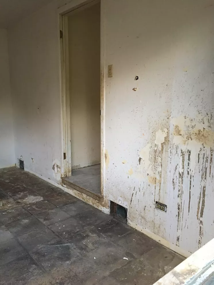 The windows have been removed from the house, so it's easy to see the damage inside. - MARK ANTONATION