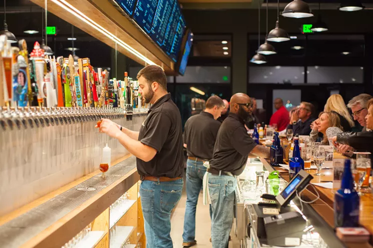 All those tap handles, and the kegs they're attached to, are owned by the separate breweries represented at places like Growler USA. - GROWLER USA