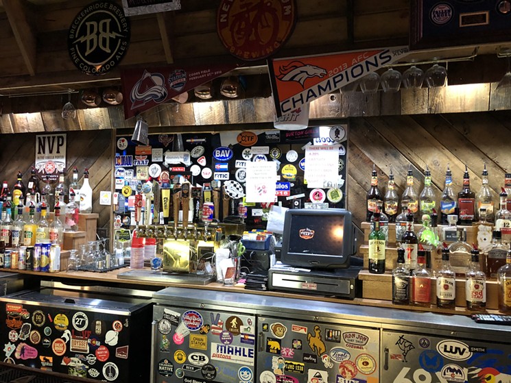Behind the bar at Mountain Tap & Grill, you'll find a lot of beer stickers and beers to go with them. - SARAH MCGILL