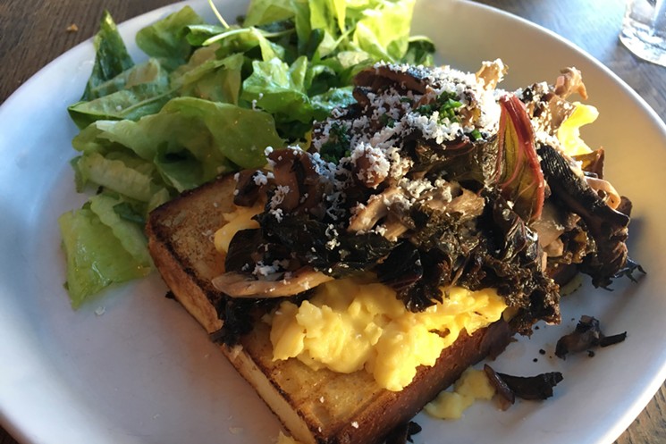 Wild mushrooms, kale and scrambled eggs top a fat wedge of toast. - MARK ANTONATION