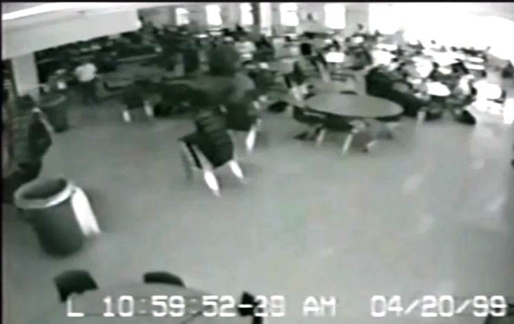 A screen capture of surveillance video shows someone at extreme left, believed to be Dylan Klebold, hauling a duffel bag into the Columbine High School commons. - FILE PHOTO