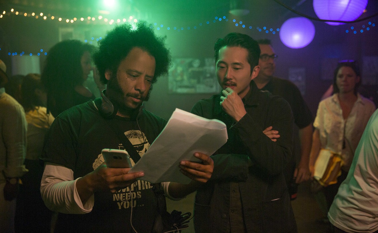 Sorry to Bother You director Boots Riley (left) confers with actor Steven Yeun on the set.
