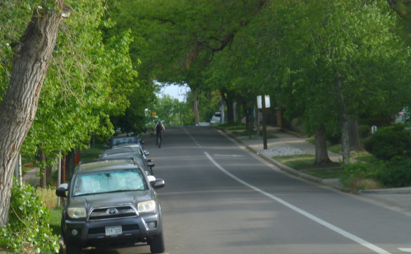 A lone bicylist heads north on the 600 block of Washington Street, where on-street parking has already been halved by a right-turn lane.