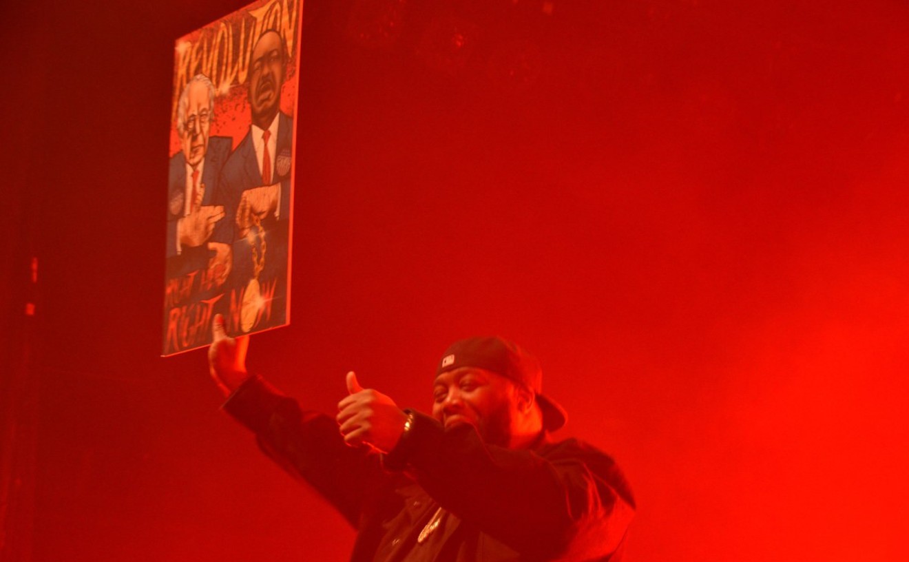 Killer Mike shows off a poster, by Danny Argote, of Bernie Sanders and Martin Luther King Jr. flashing Run the Jewels signs.