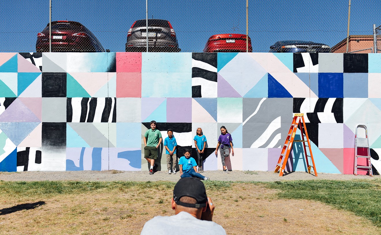 International artist Saïd Kinos takes a photo of Nicholas (left), Nico, Nivia, Timberly and Christine in front of a mural he painted with their help on Friday, September 15, at Cowell Elementary School.