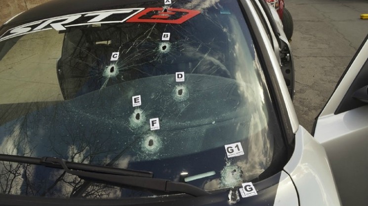 The bullet-hole-peppered windshield of Dion Damon's Dodge Charger.