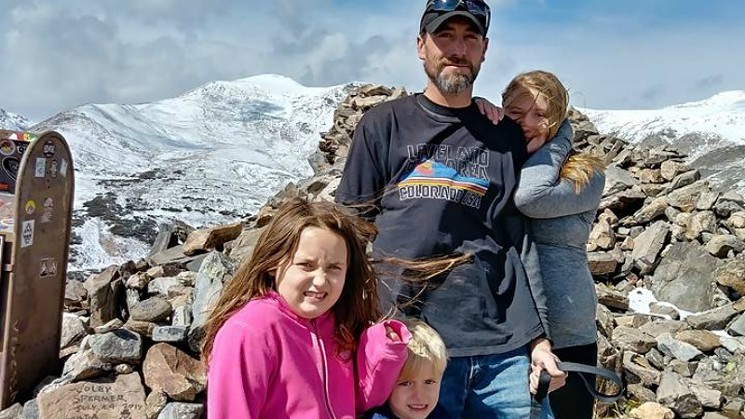 Adam Lee wearing a Loveland T-Shirt while posing with his kids in a photo shared in October 2017.