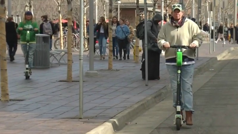 Both of the people on e-scooters seen here were riding legally in March, when the image was captured. Now, only the person in the bike lane is following current regulations.