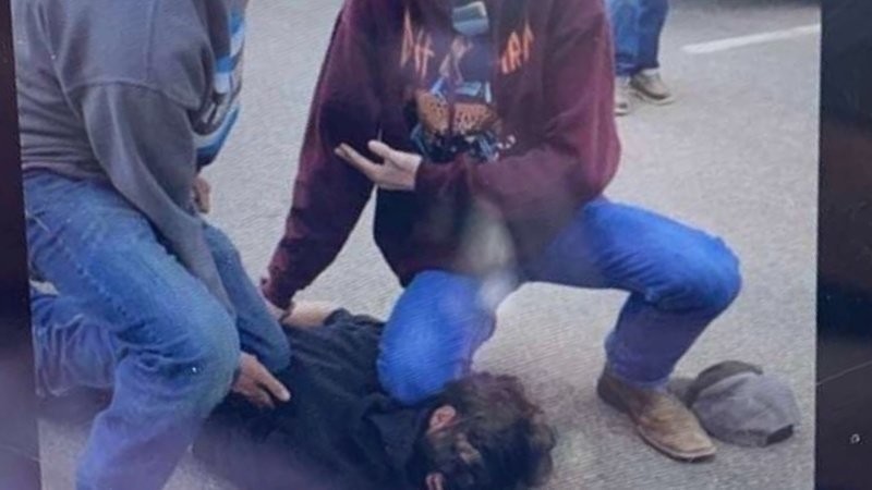 A screen capture from a broadcast image of a photo showing Mead High School students reenacting George Floyd's murder.