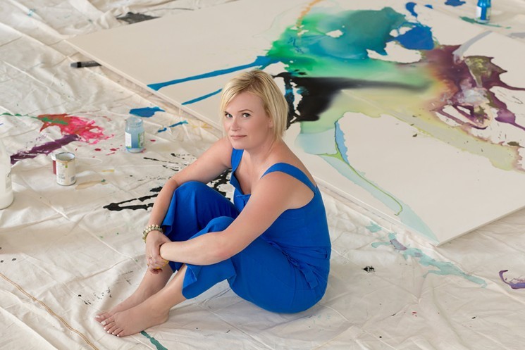 Laura Krudener sits among the colors of her work.