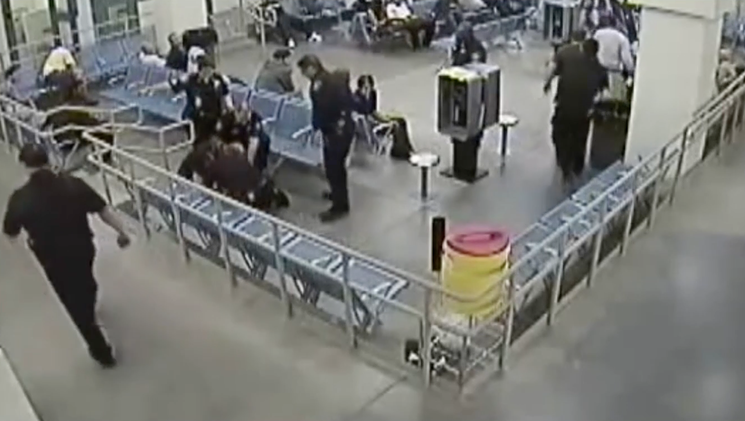 A screen capture from surveillance footage showing Denver Sheriff Department personnel piling on Marvin Booker.