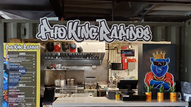 the front of a food stall with its name written in graffiti font