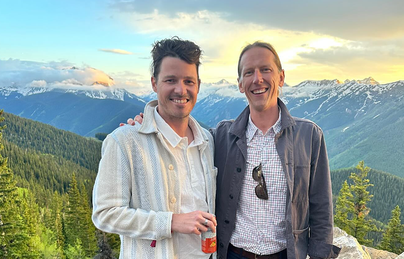 Image: two men posing with a mountain backdrop