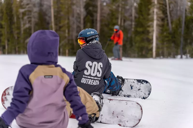 Image: A boy snowboards.