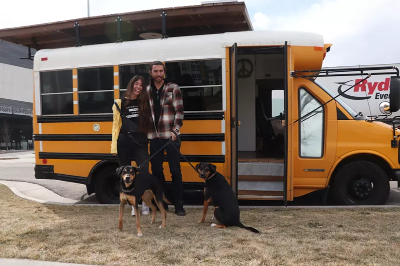 Image: Kelsey Keserich and Luke Bender standing outside their bus in Denver.