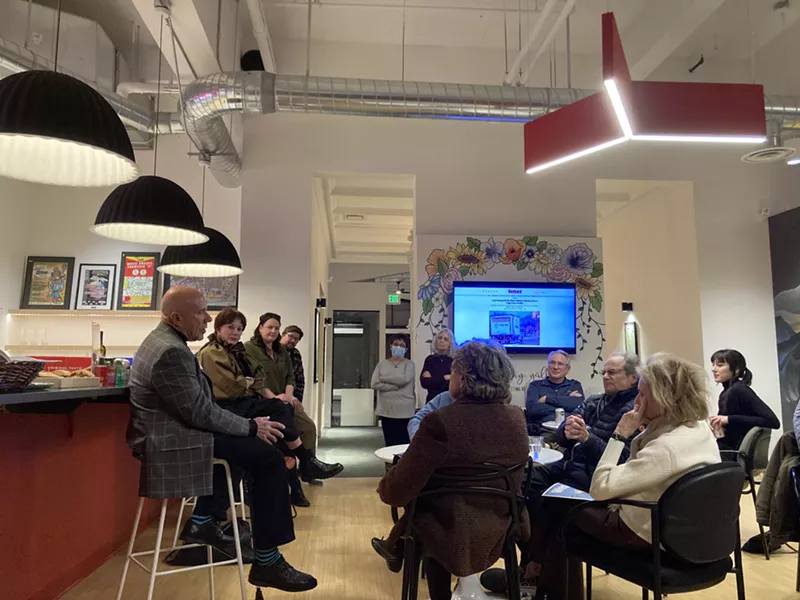 Image: man talking to gathering in office