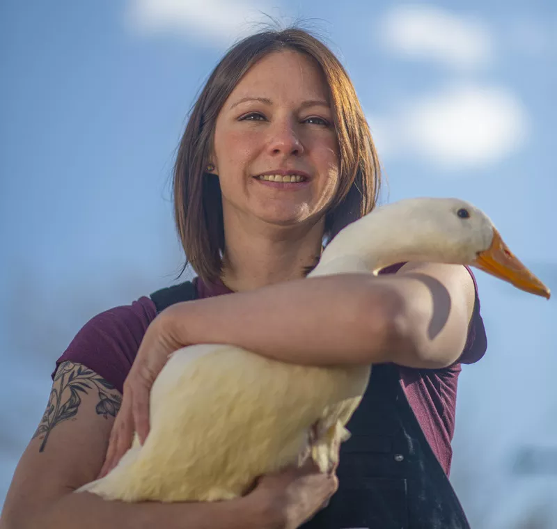 Image: Woman with duck against blue sky