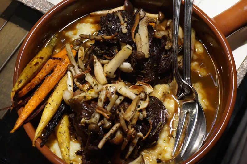 Image: Braised beef shank stuffed with bone marrow and served with roasted carrots, mushrooms and polenta.