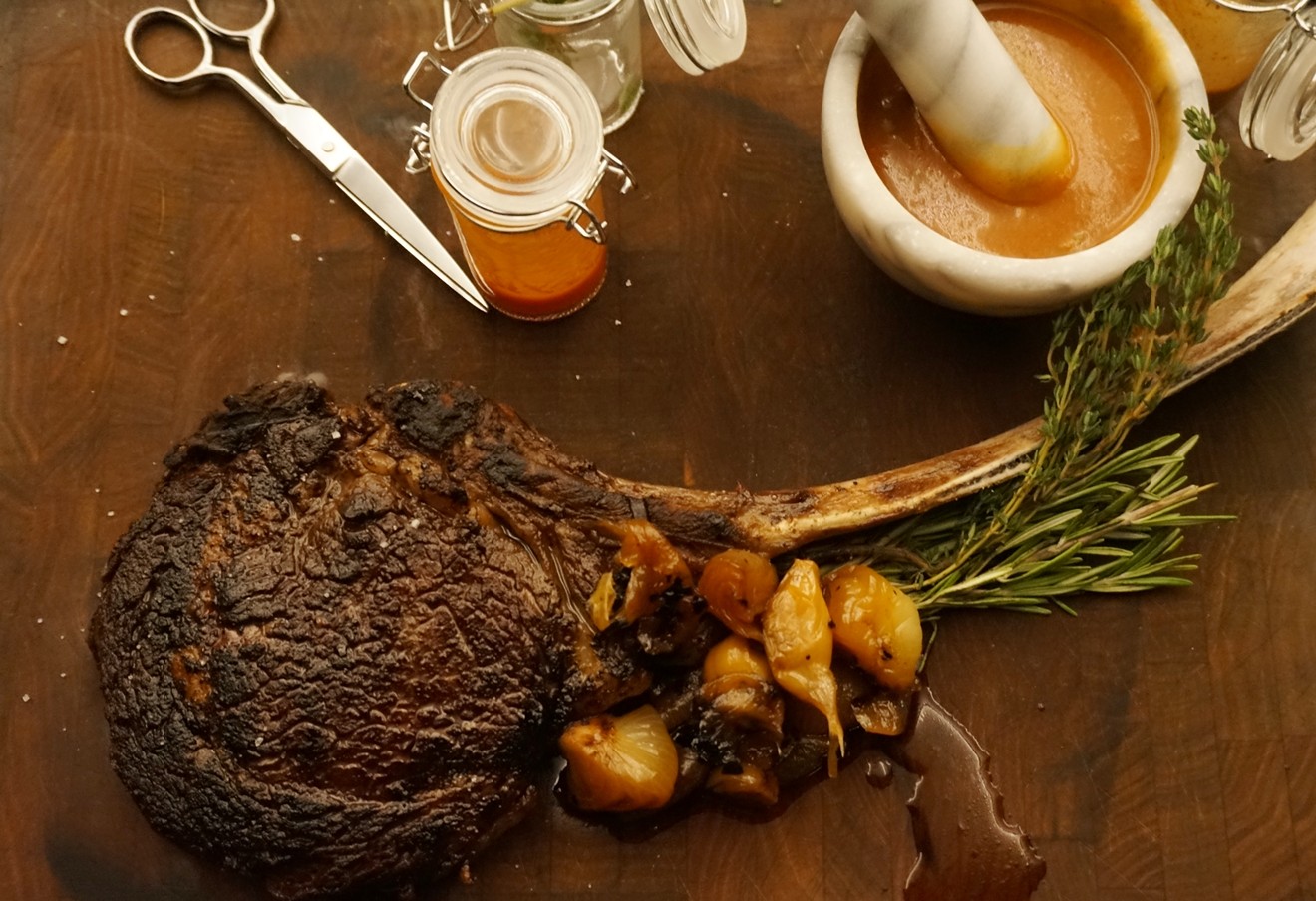Quality Italian's tomahawk ribsteak comes with sauce prepared tableside with a mortar and pestle.