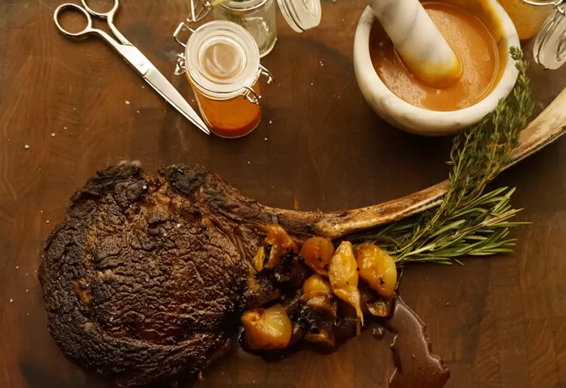 Image: Quality Italian's tomahawk ribsteak comes with sauce prepared tableside with a mortar and pestle.