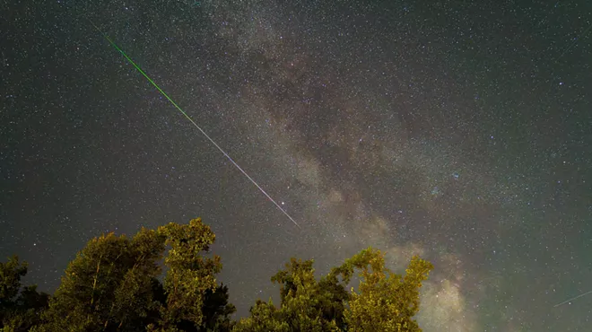 A shooting star streaks across the sky