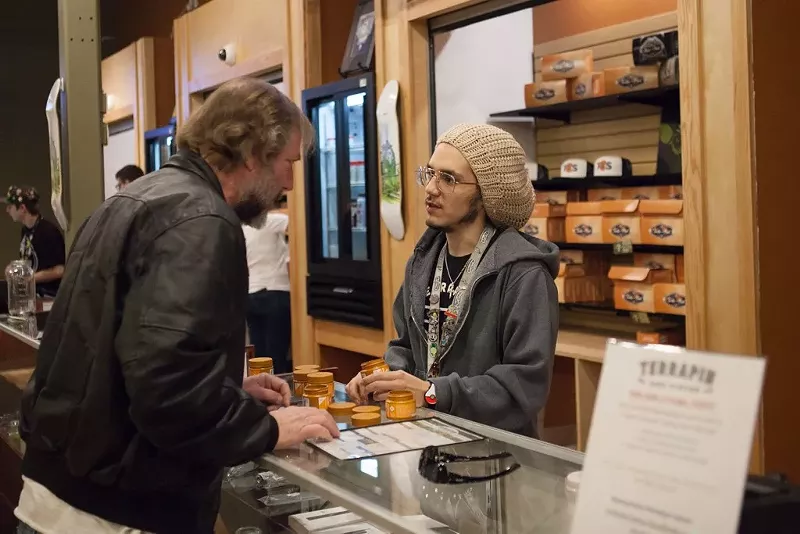 Image: A Terrapin Care Station dispensary budtender helps a customer in in Aurora.