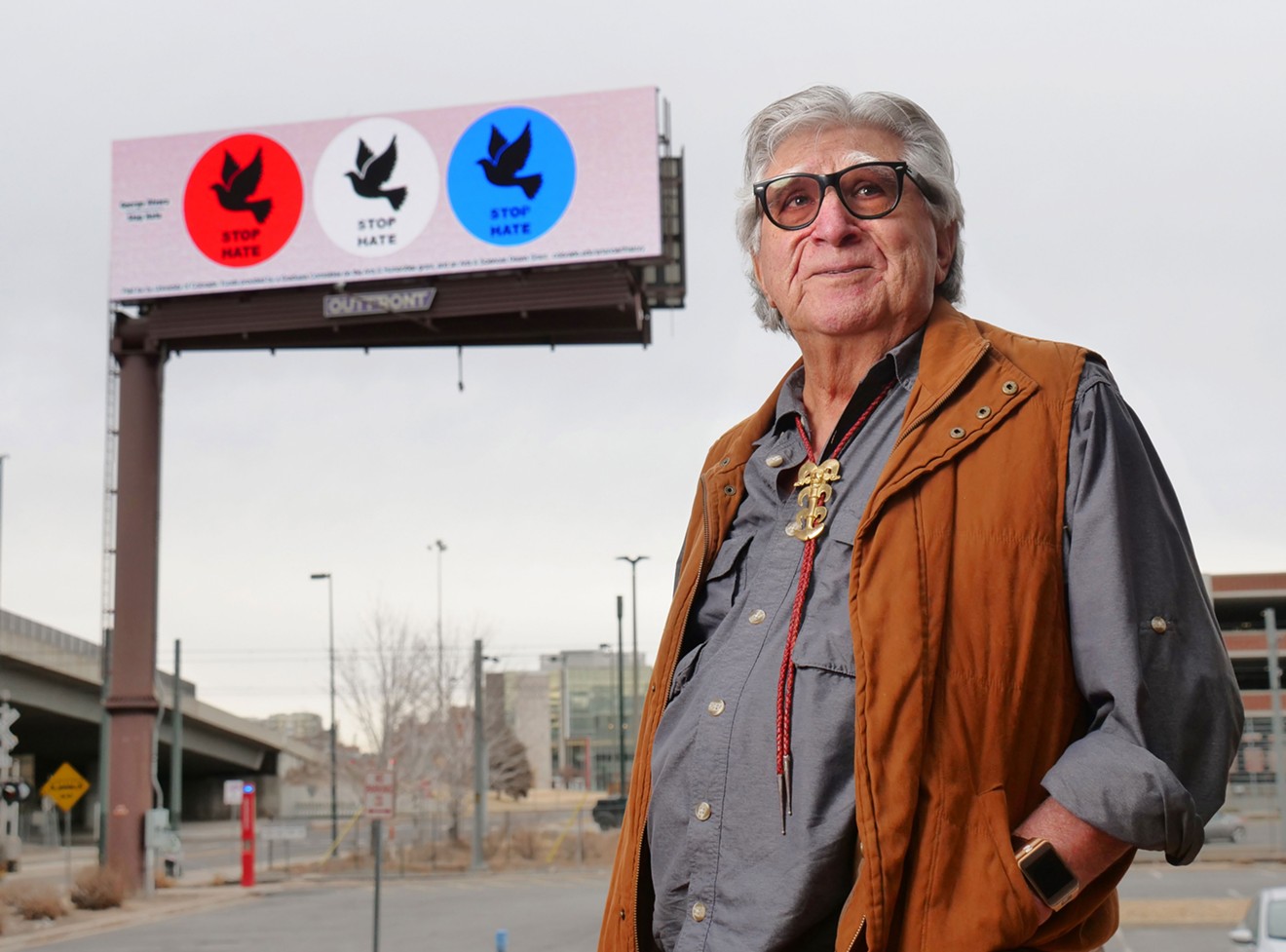Artist George Rivera stands in front of his “Stop Hate” billboard on the Auraria campus in Denver.