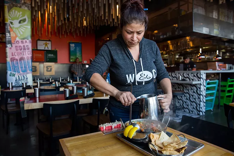 Image: Chef Dana Rodriguez pours the hot stone stew tableside at Super Mega Bien.