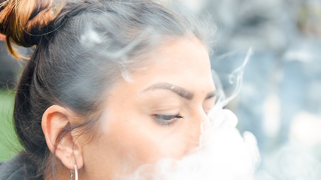 Woman blows cloud of smoke