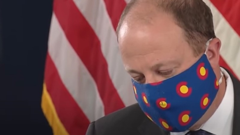 A photo of a masked Governor Jared Polis from 2020.
