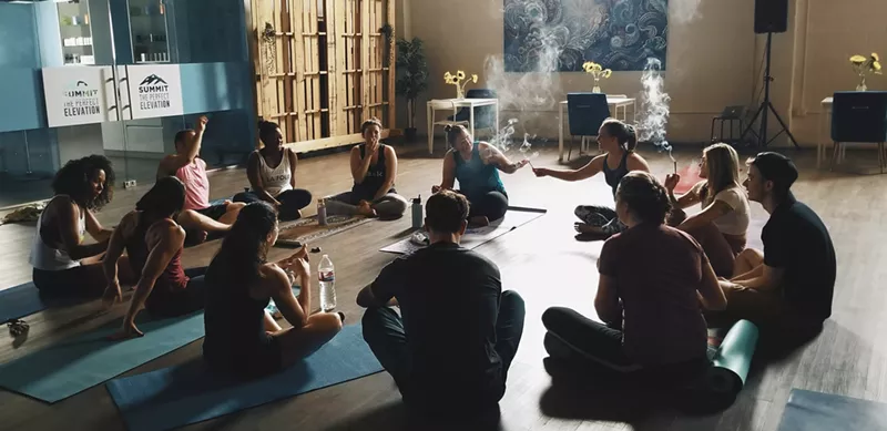 Image: Members of a Bend & Blaze class share a joint before a yoga session.