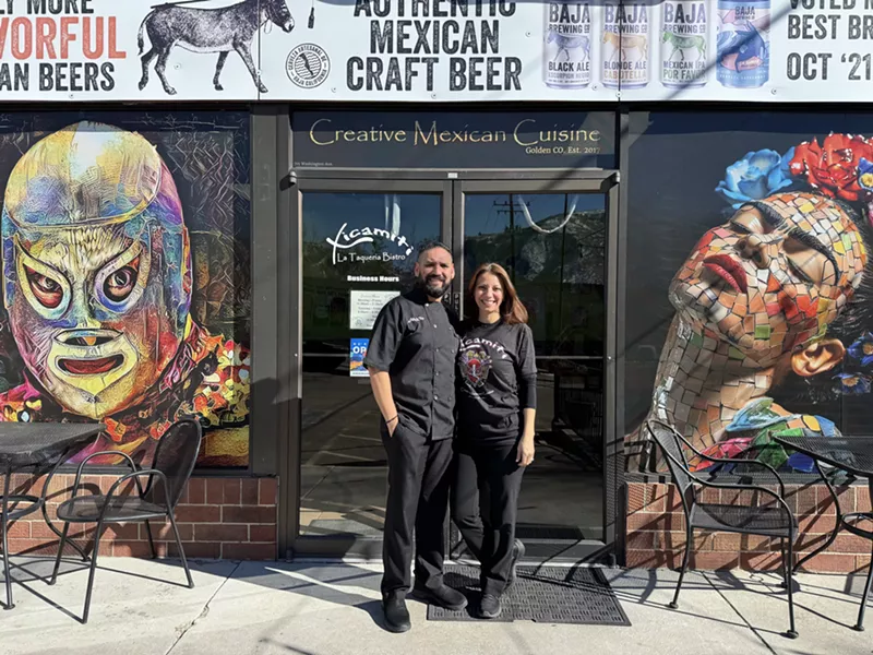 Image: man and woman standing in front of a restaurant front door