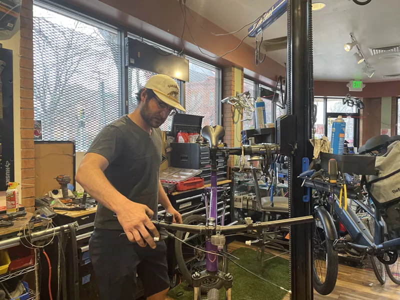 Image: Dmitri Rumschlag works on a bicycle.