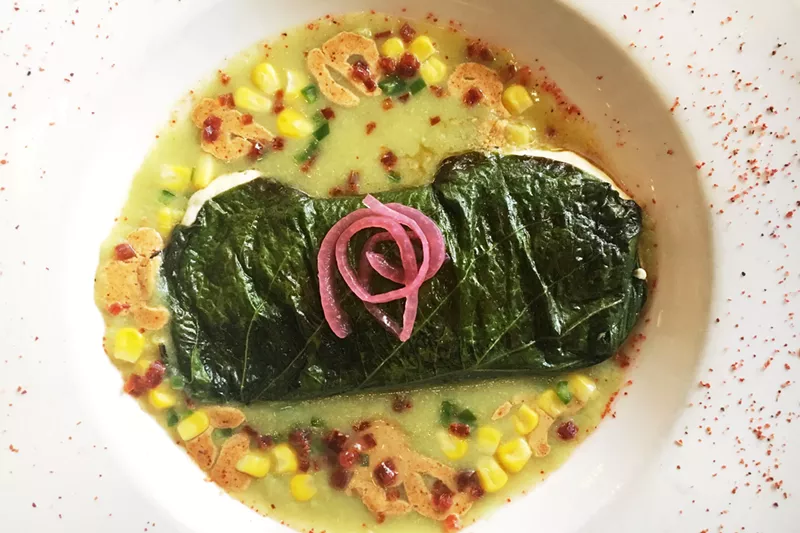 Image: An hoja santa relleno with a chorizo, corn and tomatillo sauce.